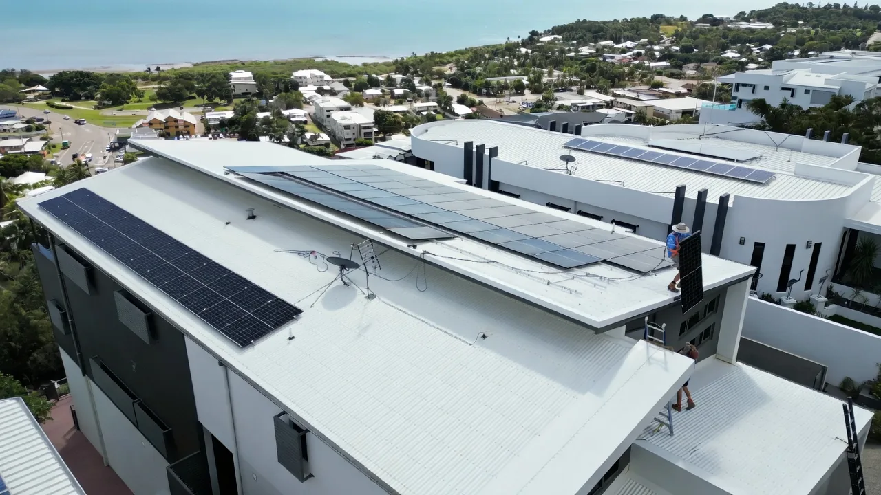 Townsville Solar Battery and Off-Grid | Barra Solar Power Townsville A Barra installer carrying a solar panel across a Townsville roof